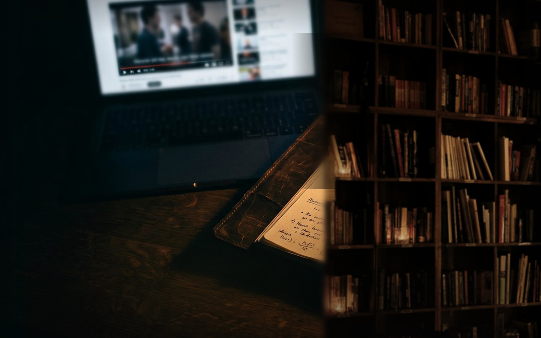 Workbook abierto con ejercicios escritos a mano junto a un laptop con un video en pausa, sobre un escritorio de madera oscura iluminado por una lámpara cálida